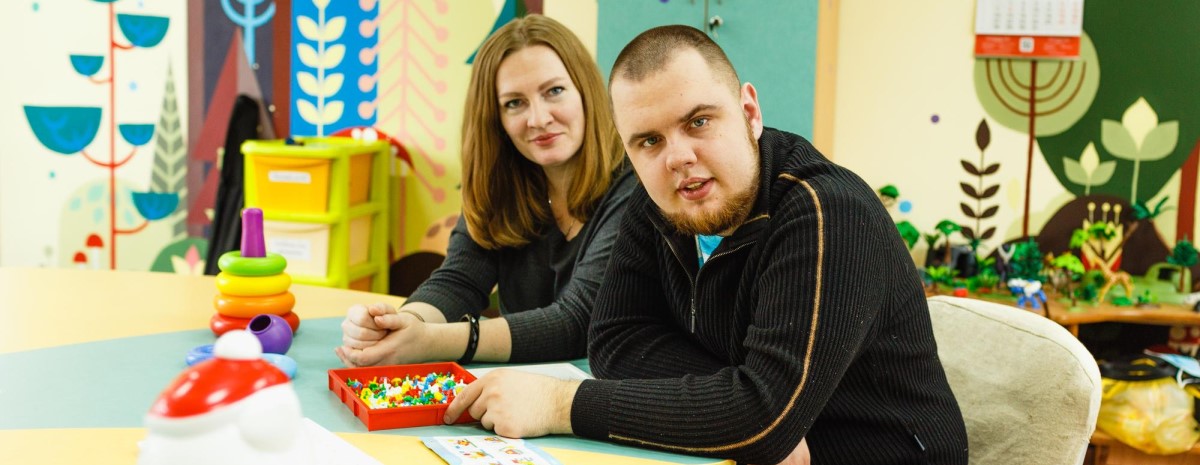 A man with Autism explores activities and games with a female therapist.